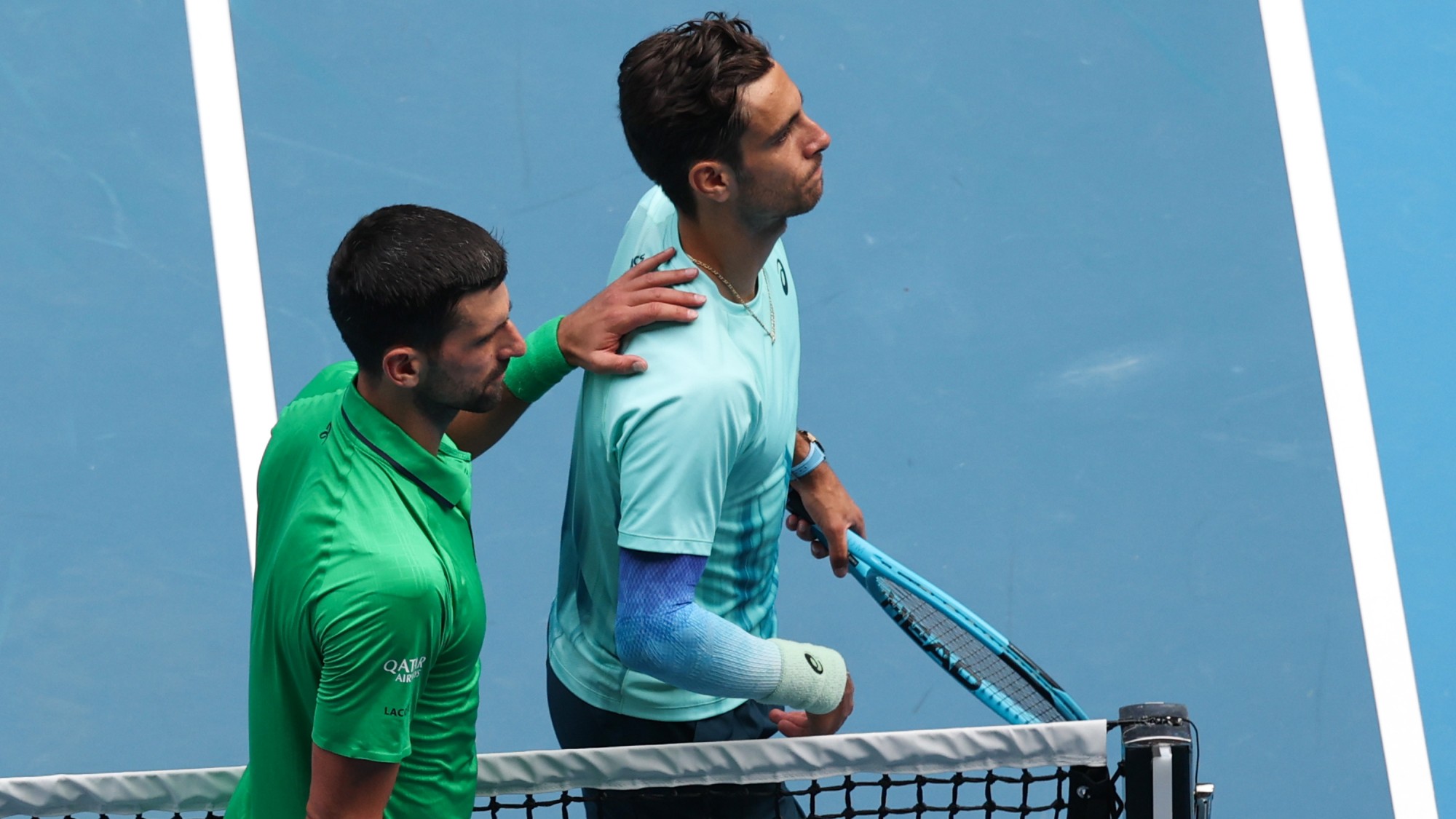 Novak Djokovic (alul) és Lorenzo Musetti az Australian Open negyeddöntője után. Az olasz sérülés miatt feladta, noha kétszettes előnyben volt.