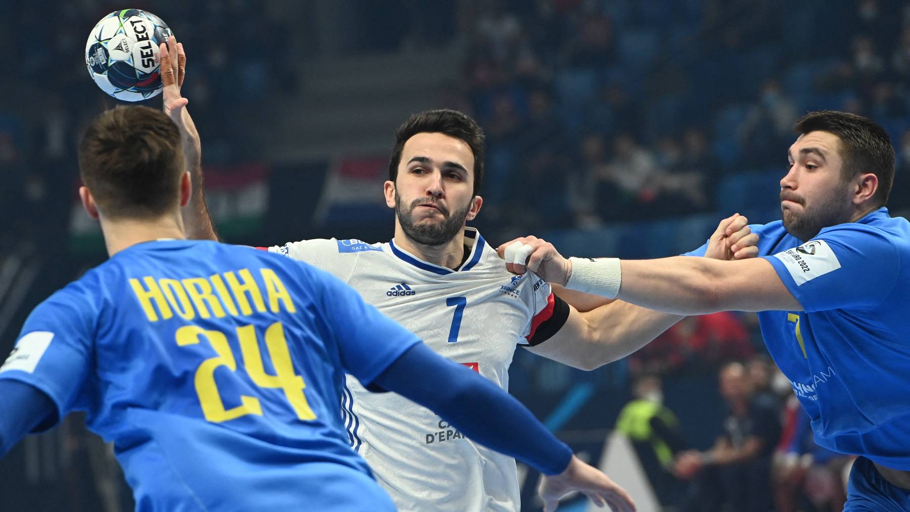 France's left back Romain Lagarde (C), Ukraine's left back Dmitro Horiha (L) and Ukraine's Dmytro Ilchenko (R) vie for the ball during the Men's European Handball Championship preliminary round match between France and Ukraine in Szeged, Hungary on January 15, 2022.