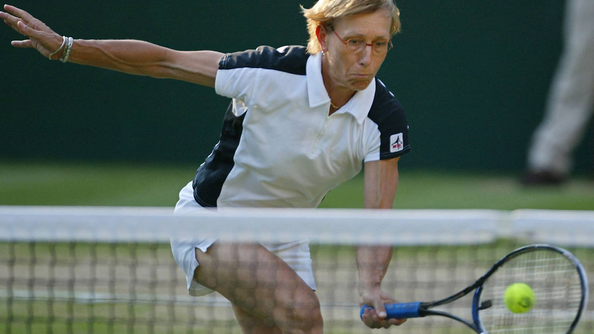 Martina Navratilova of the US hits a ball at the net as she and Leander Paes of India play their Mixed Doubles Final against Andy Ram of Israel and Anastassia Rodionova of Russia at the Wimbledon Tennis Championships 06 July, 2003 in Wimbledon, south London. Navratilova/Paes won 6-3, 6-3 and Navratilova won her 20th Wimbledon Championship title.