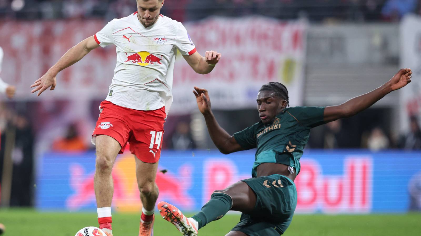 Leipzig's Austrian midfielder #14 Christoph Baumgartner and Bremen's German defender #31 Karim Coulibaly vie for the ball during the German first division Bundesliga football match between RB Leipzig and Werder Bremen in Leipzig on November 23, 2025.